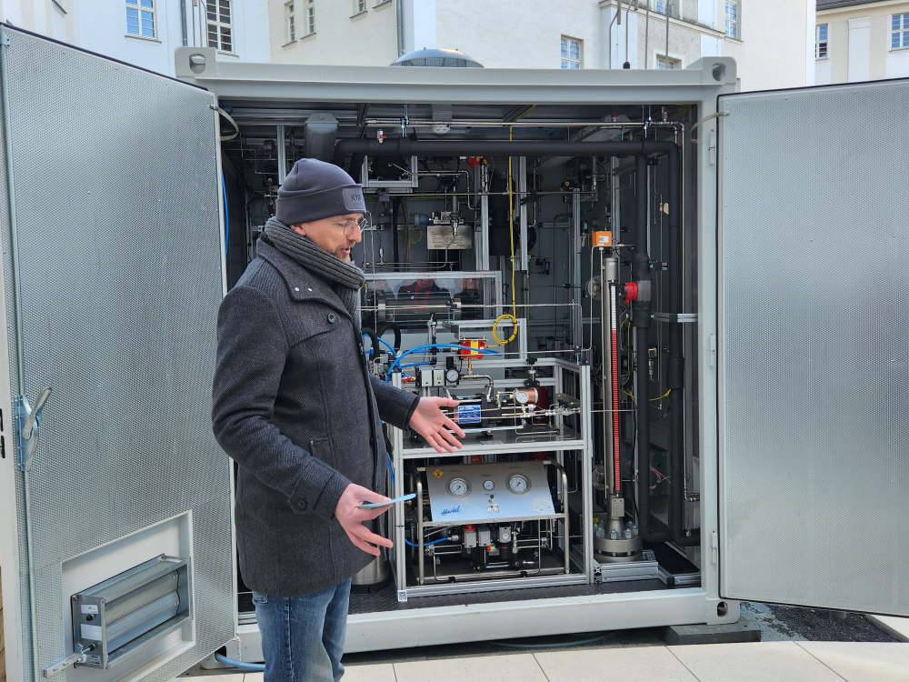 Projektmitarbeiter von Kyros Hydrogen Solutions erklärt die Funktionsweise des Elektrolyseurs in Sonneberg
