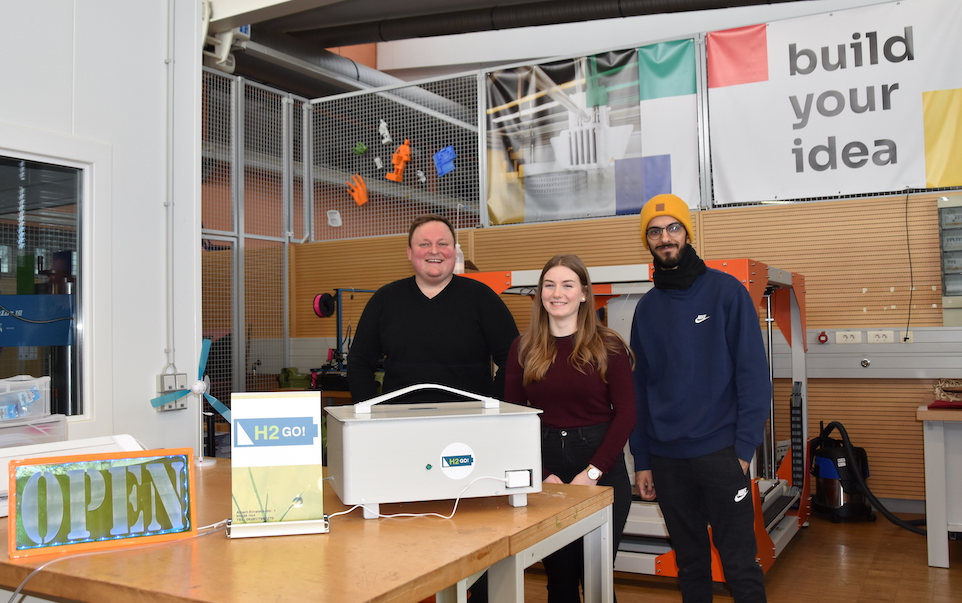 Tommy Hofmann (links), Dorothea Rosinski und Jonas Othmann vom Gründerteam H2go mit ihrem Prototypen einer mobilen Brennstoffzelle. Foto: Hochschule Hof